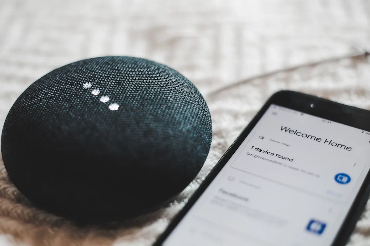 Phone beside a fabric-covered smart speaker