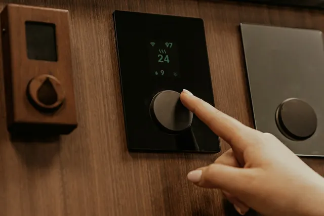 Finger adjusting a wall-mounted dimmer control