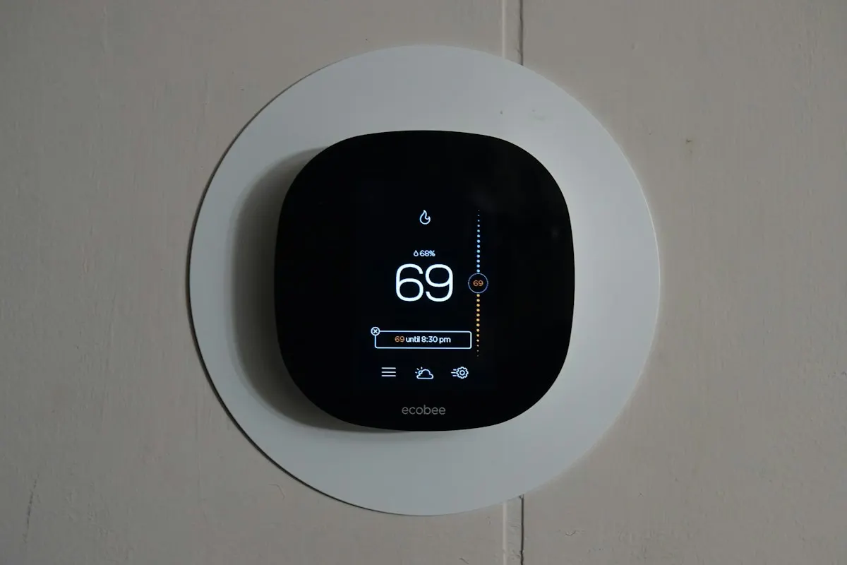Round digital thermostat on an interior wall